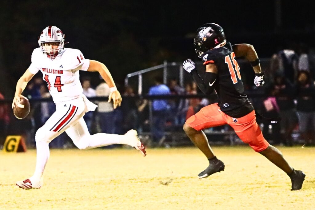Hawthorne's Javontae Williams (18) pressures Williston quaterback John Jazikoff (14) in the Rural-Region 4 Final. Photo by C.J. Gish 1