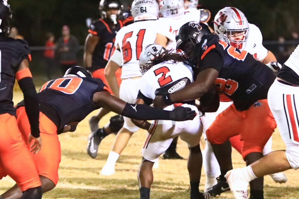 Hawthorne's Kyler Ingram (10) and Demeion Rutledge (28) bring down Williston's J'Dyen Manneh (2) in the Rural-Region 4 Final. Photo by C.J. Gish