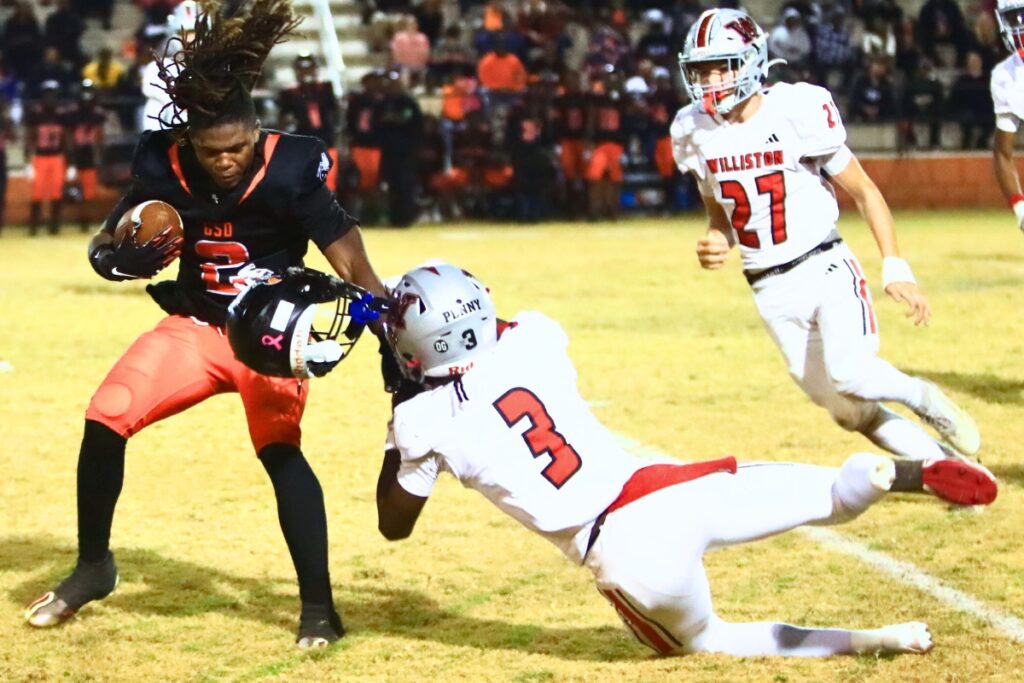 Hawthorne's Nathan Jennings (2) loses his helmets on a third-quarter reception while being tackled by Williston's Kyrin Penny in the Rural-Region 4 Final. Photo by C.J. Gish