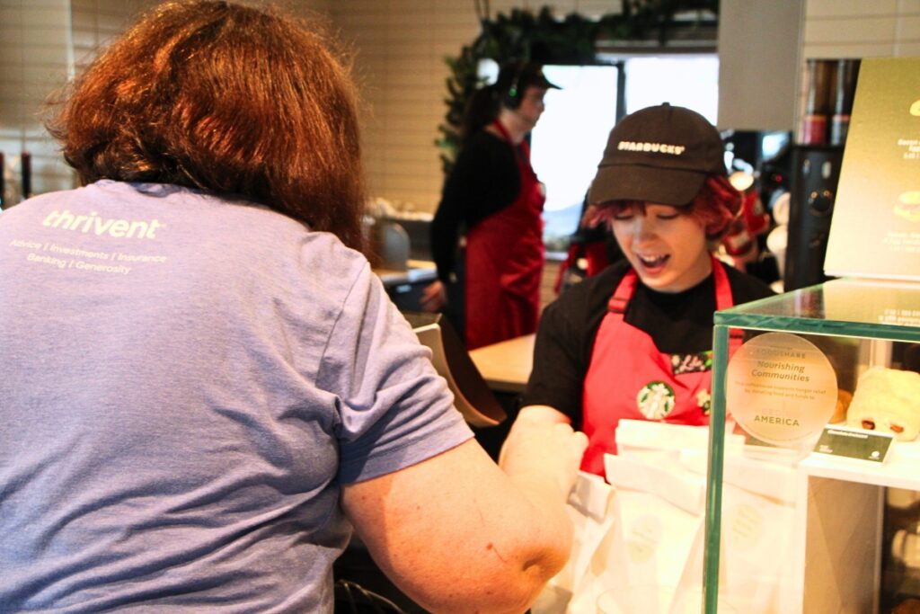 Karen Kearney (left) surprises Starbucks employees working on Thanksgiving with lunches from Operation Turkey Sandwich. Photo by Lillian Hamman (1)