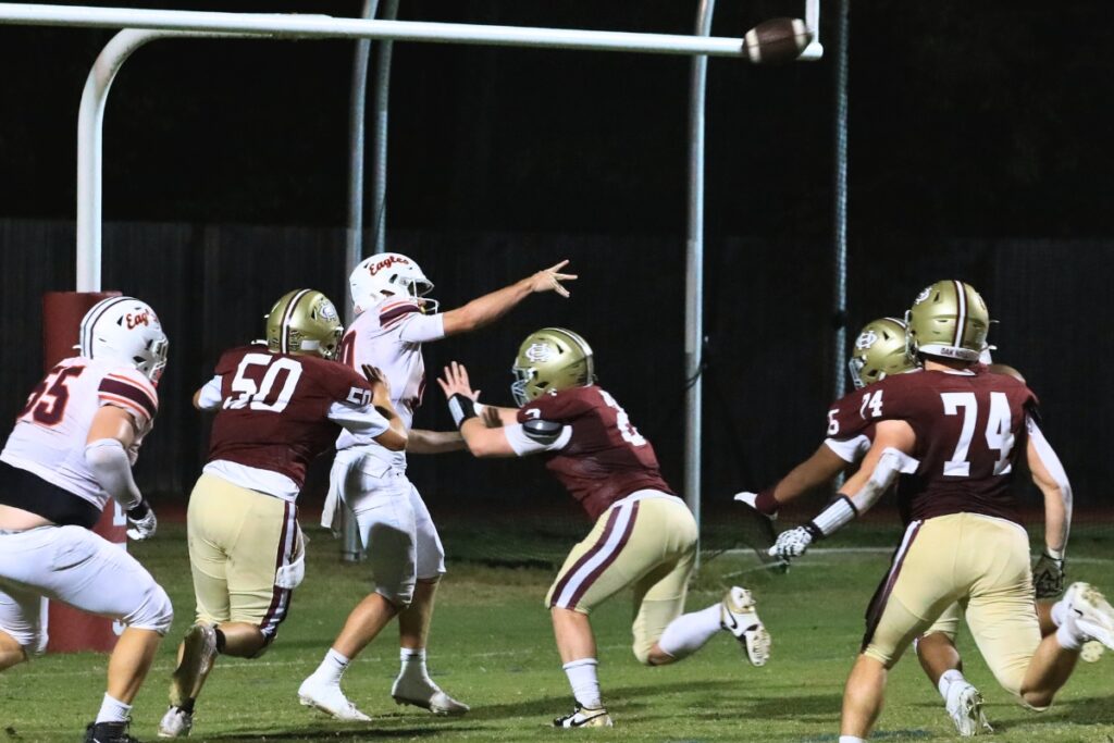 Oak Hall defenders pressure Christ's Church Academy's (Jacksonville) quarterback John Upchurch. Photo by Seth Johnson