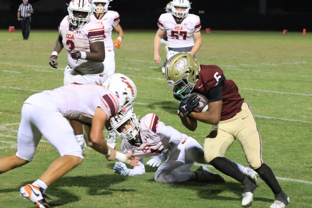 Oak Hall's Darius Medley runs against Christ's Church Academy (Jacksonville) defenders. Photo by Seth Johnson