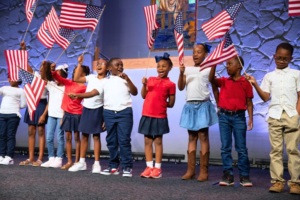 Students from the Caring & Sharing Learning School of Gainesville sing “This Land is Your Land.” The children performed with direction from Angela Terrell, the arts director at the school.