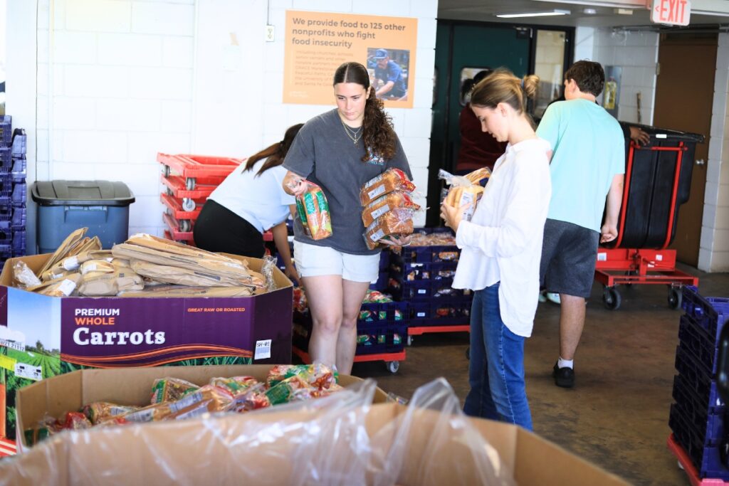 Volunteers help sort food items at the Bread of the Mighty in Gainesville. Photo by Seth Johnson