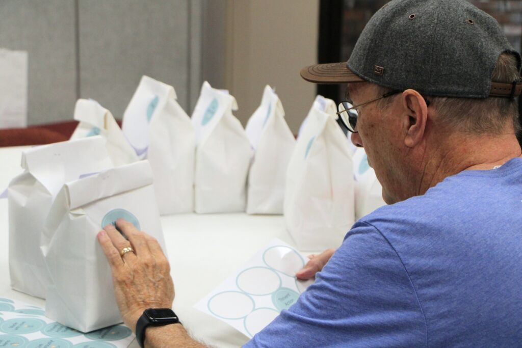 Volunteers put stickers on lunch bags packaged for Operation Turkey Sandwich. Photo by Lillian Hamman