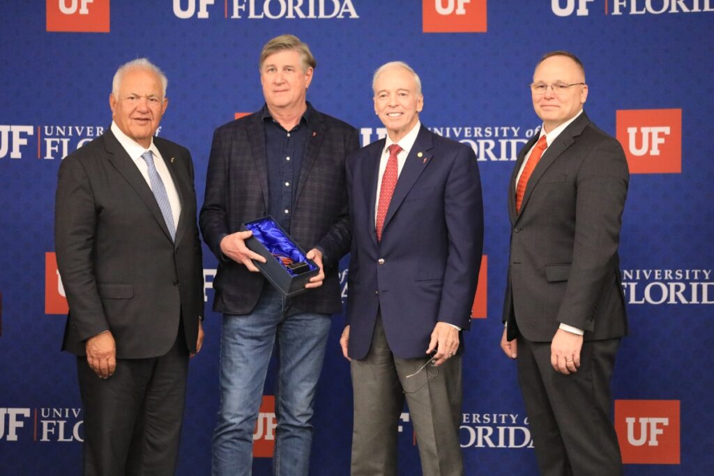 Dr. Read Hayes (second from left) accepts the Win Phillips Town Gown Relations Award for his work in retail loss prevention. 