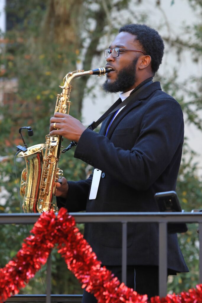 Emmanuel Garilus, co-grand marshal, plays the saxophone during A Very GNV Holiday Parade. Photo by Seth Johnson