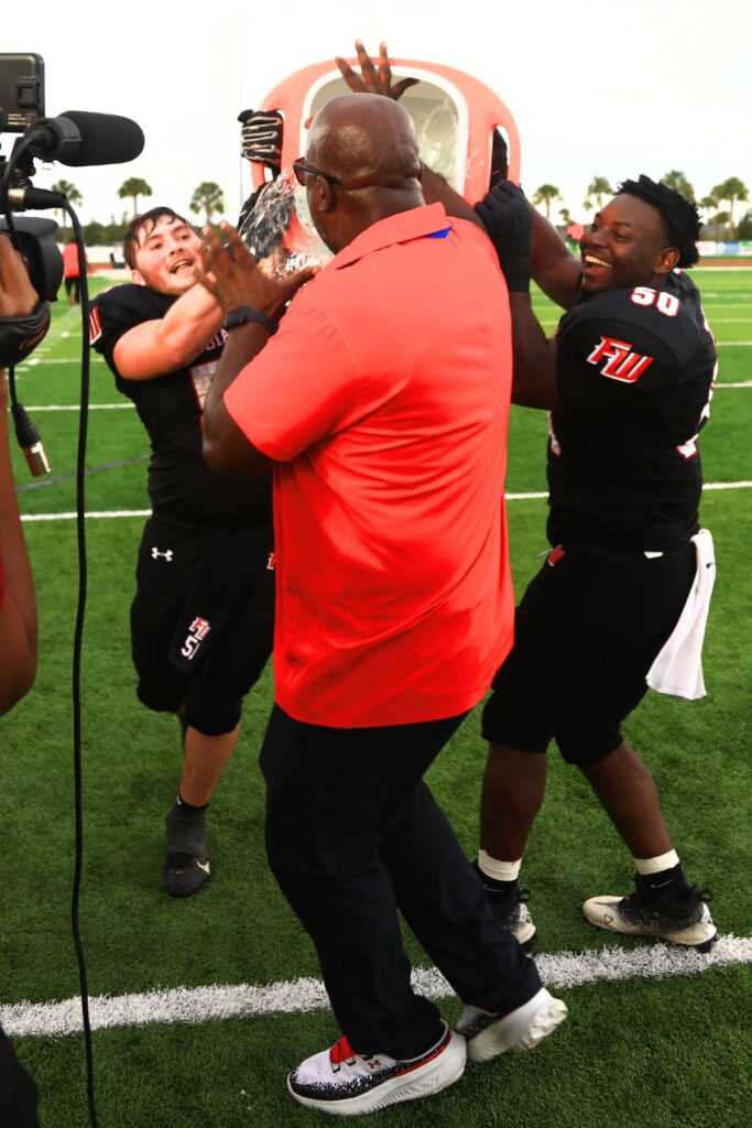 Fort White head coach Demetric Jackson (center) gets doused by players Bo Jones (51) and Thailen Buiey (50) after winning Rural Florida Invitation Tournament Championship game. Photo by C.J. Gish