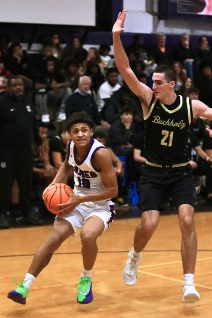 Gainesville's Bronx Johnson (10) drives to the basket against Buchholz's Gabe Williams (21). Photo by C.J. Gish