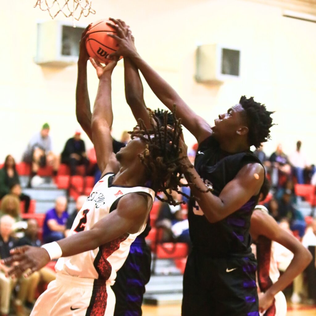 Gainesville's Corvaughn White (3) and Williston's Jaden Magee (2) battle for a rebound. Photo by C.J. Gish