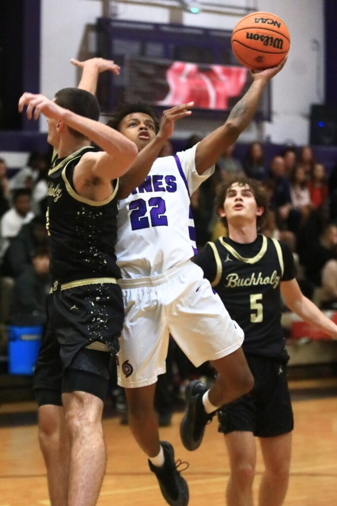 Gainesville's Davarion Howard (22) drives to the basket against Buchholz's Gabe Williams (21). Photo by C.J. Gish