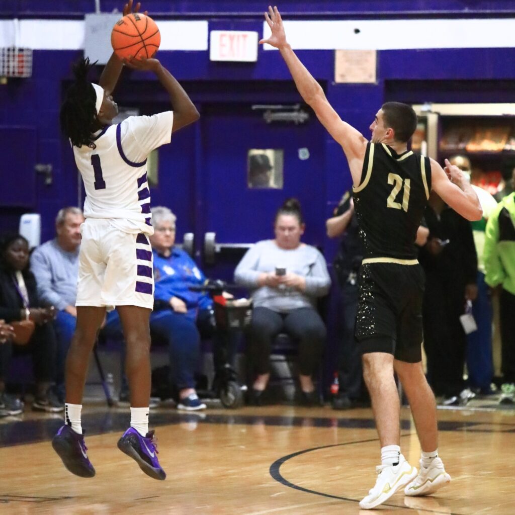 Gainesville's Willie Brooks (1) launches a 3-point shot against Buchholz's Gabe Williams (21). Photo by C.J. Gish