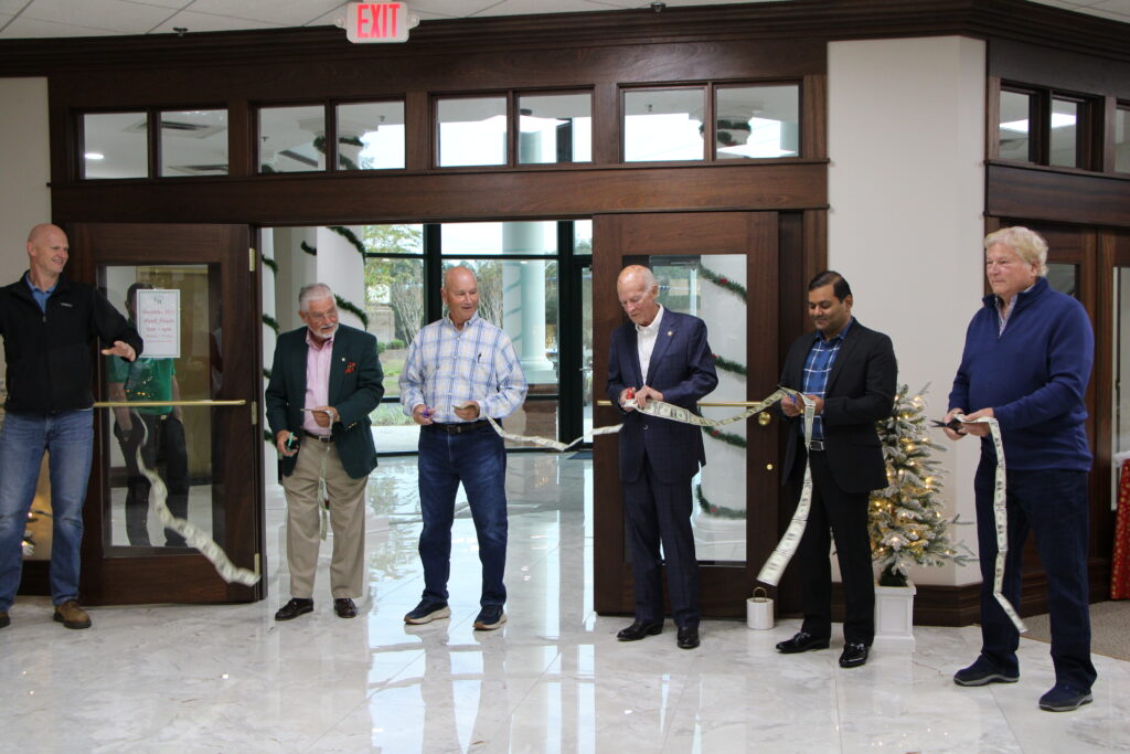 Gala Bank officials cut the ribbon of one-dollar bills to open its new branch in Tower Hill Plaza. 