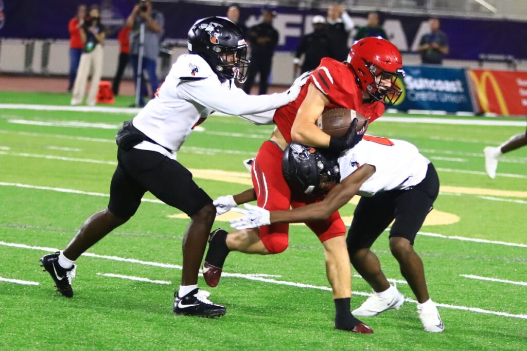 Hawthorne's Darian Bowe (1) upends a Blountstown receiver in the first quarter of the FHSAA Rural State Championship game. Photo by C.J. Gish