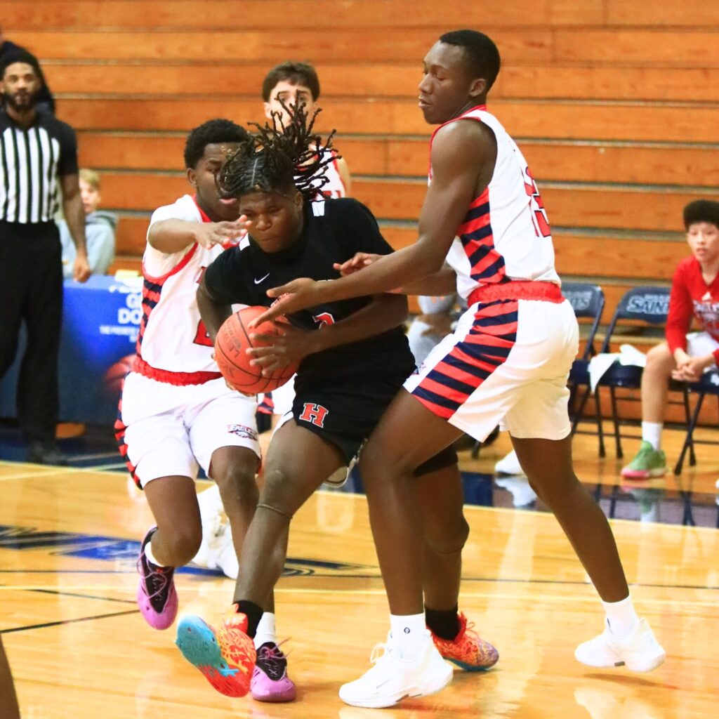 Hawthorne's Nathan Jennings (2) splits a pair of defenders on his way to the basket against North Florida Education Institute (Jacksonville). Photo by C.J. Gish