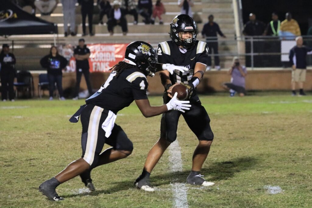 Justin Williams takes the snap and hands the ball to Josh Menefee for a run. 