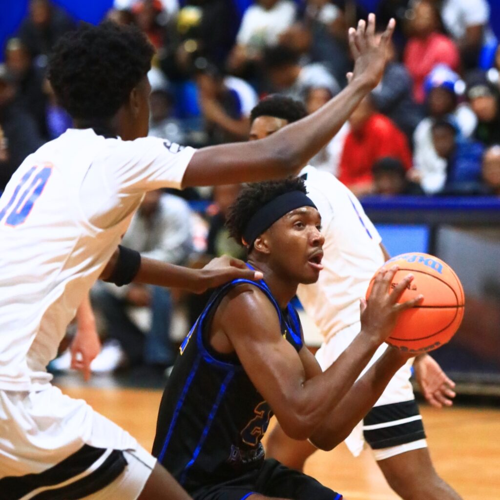 Newberry's Juwan Scippio (24) drives to the basket against P.K. Yonge's Eugene Hall (10). Photo by C.J. Gish
