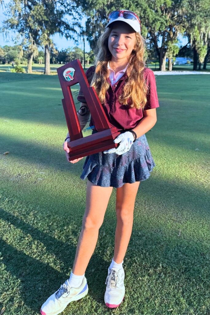 Oak Hall golfer Scarlett Konecny with the 1A District 5 team championship trophy. Courtesy of Mike Mueller
