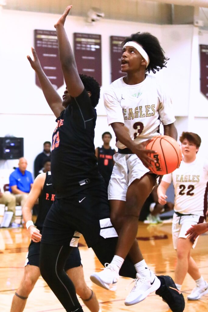 Oak Hall's Amari Ray (3) drives to the basket against P.K. Yonge's Willie Spain (23). Photo by C.J. Gish