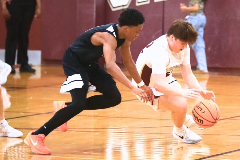 Oak Hall's Cameron Currire (22) dives for a loose ball against P.K. Yonge's Jayden Harriott (5). Photo by C.J. Gish