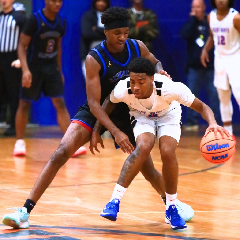 P.K. Yonge's Decedric Sowell (4) protects the ball against Newberry's Juwan Scippio (24). Photo by C.J. Gish