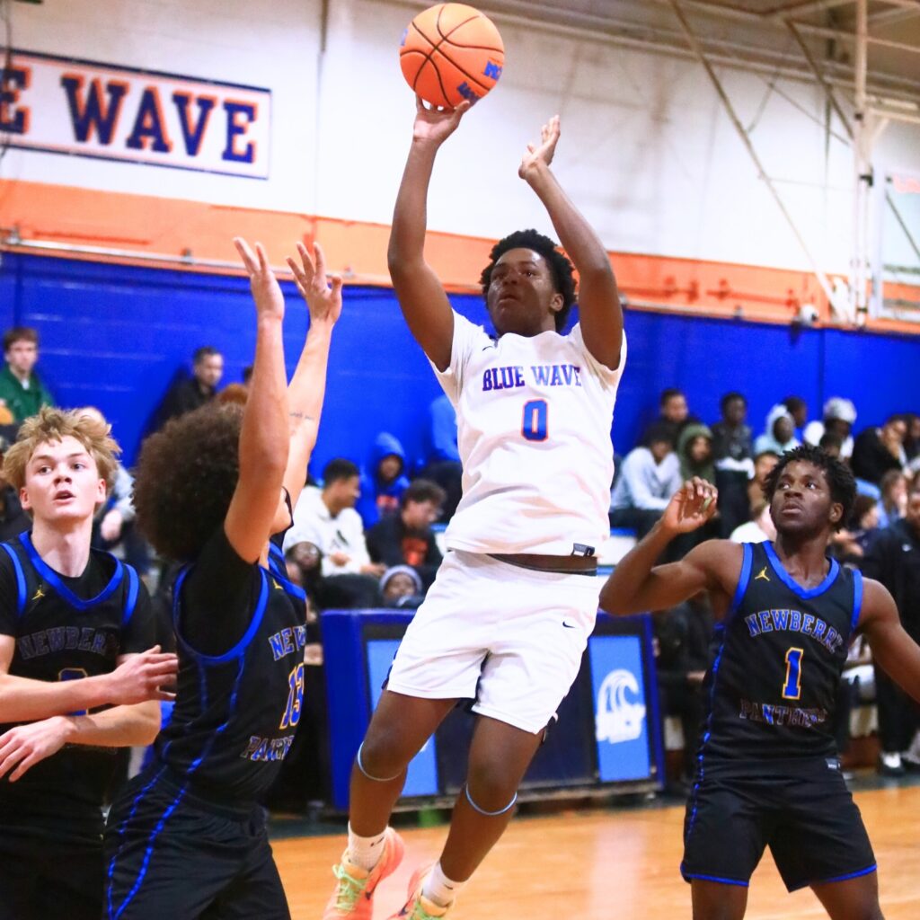 P.K. Yonge's Justin Speer (0) with a shot over Newbery's Kai Washington (13). Photo by C.J. Gish