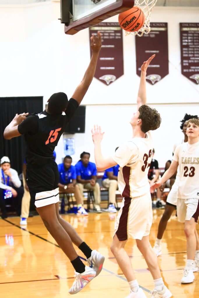 P.K. Yonge's Tray’Sean Jones (15) grabs throws up a shot against Oak Hall's Elijah Medved (32). Photo by C.J. Gish