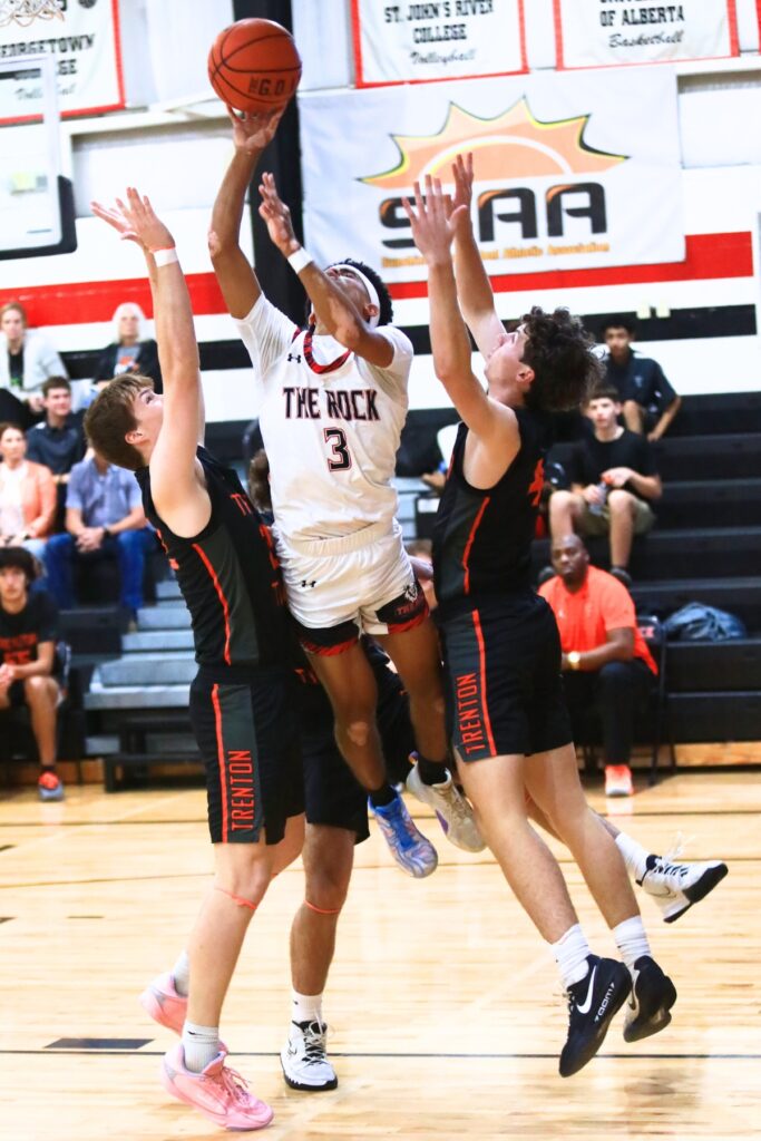 The Rock's Kayden Merricks (3) puts up a shot surrounded by three Trenton defenders. Photo by C.J. Gish 1
