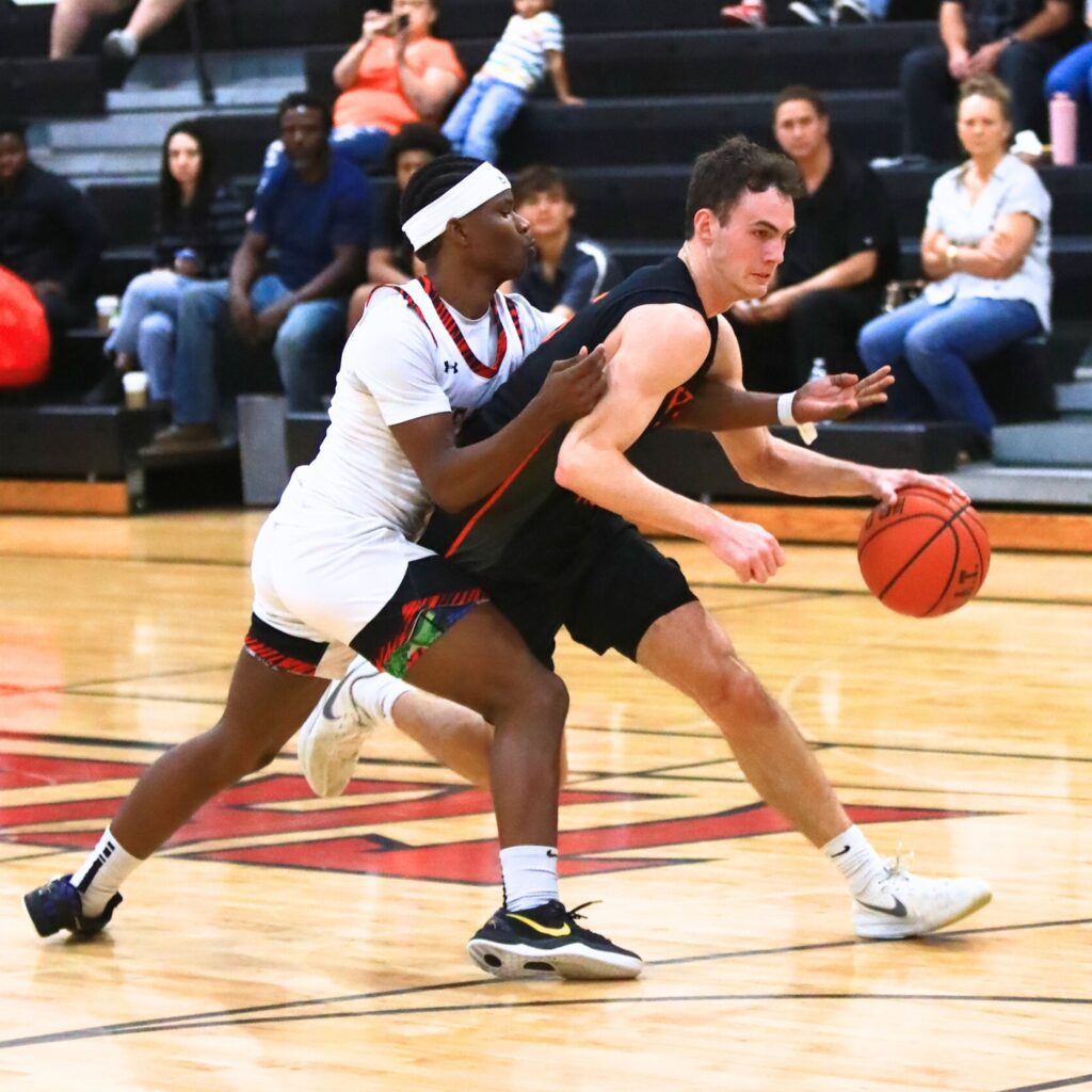Trenton's Mason VunCannon (5) drives past The Rock's Josiah Hurst (0). Photo by C.J. Gish 1