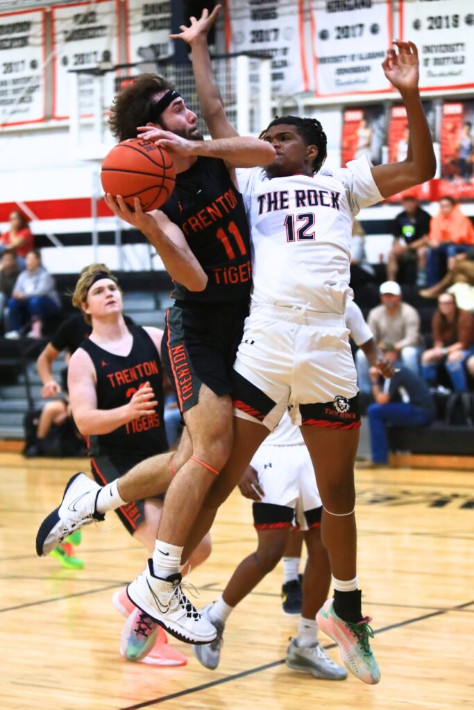 Trenton's Nathan Ridgell (11) drives to the basket against The Rock's Jafari Hicks (12). Photo by C.J. Gish 1