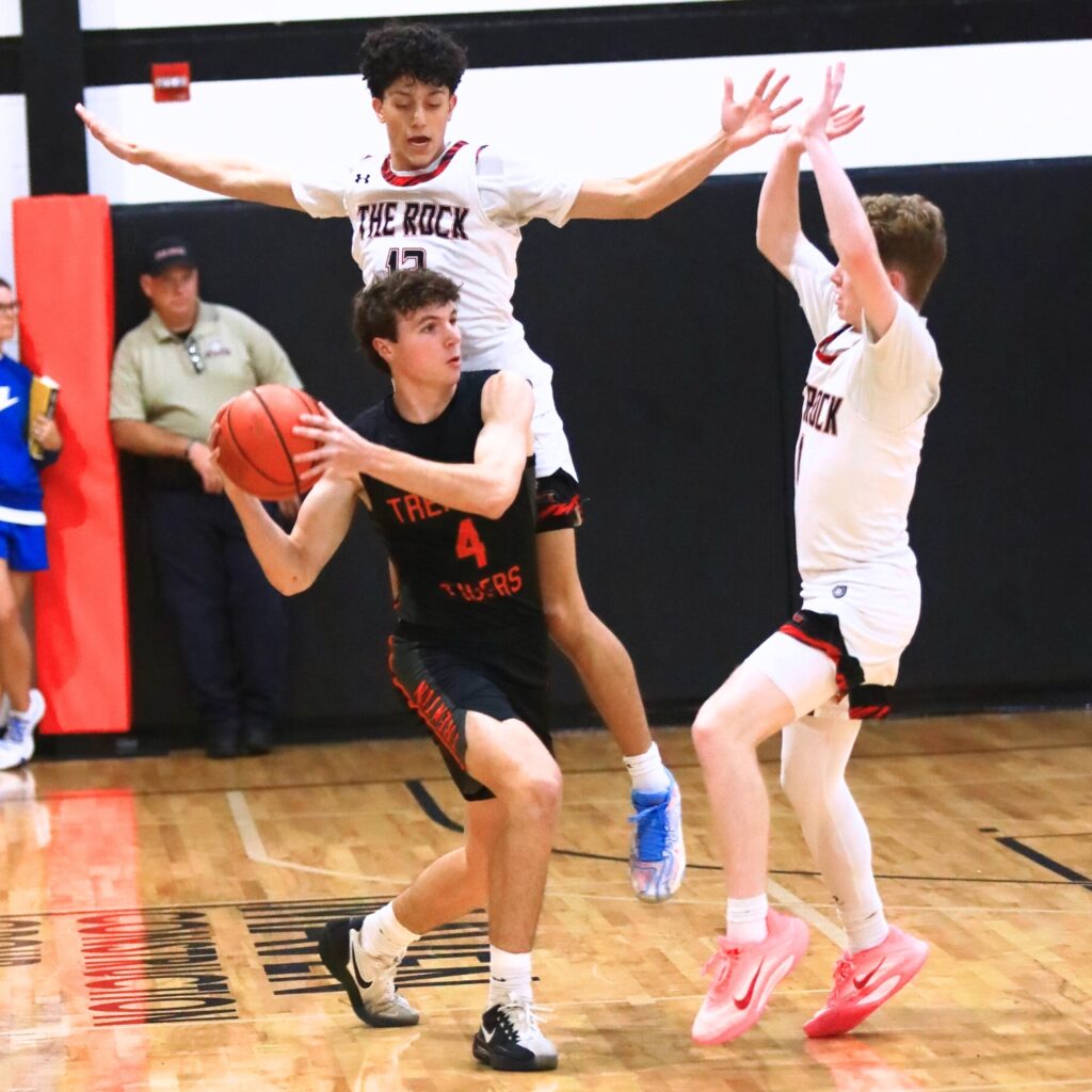 Trenton's Noah Owens (4) looks to pass against The Rock's Levi Hyatt (13) and Evan McCumber (1). Photo by C.J. Gish 1