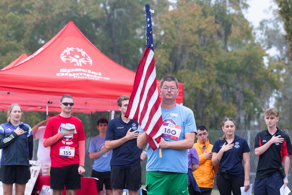 UF Special Olympics athlete leader Michael Smith leads the national anthem.