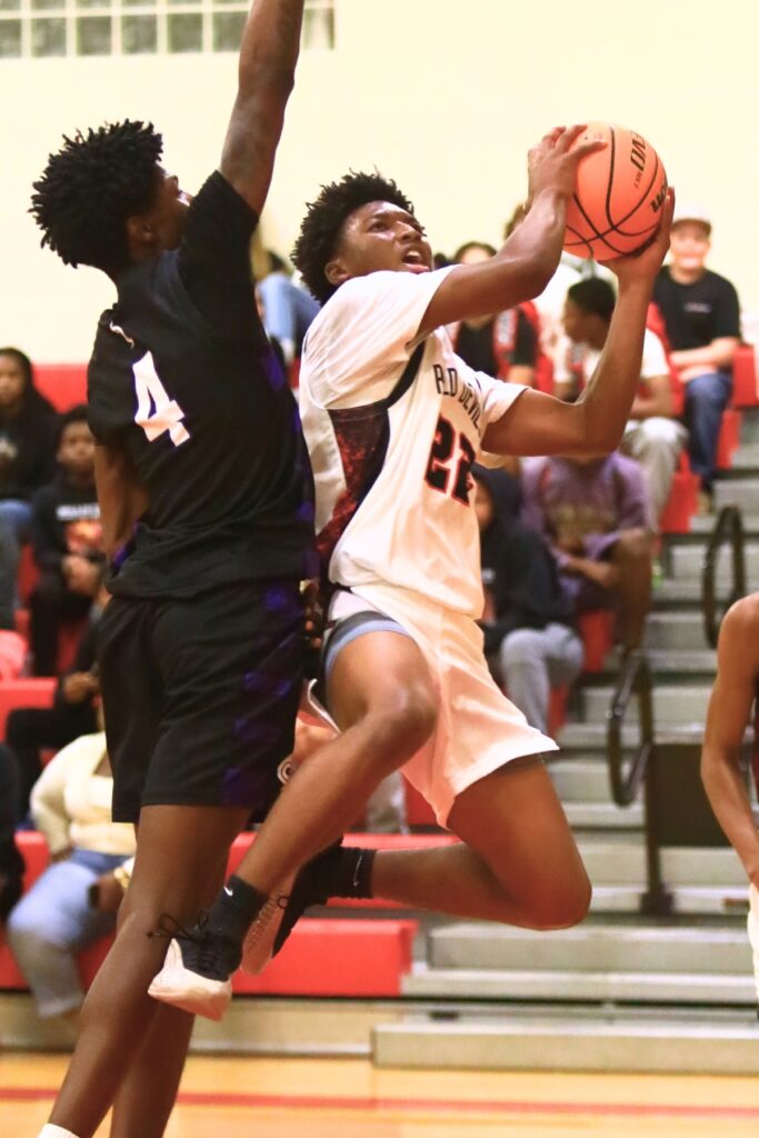 Williston's Traeston Armstrong (22) drives to the basket against Gainesville's Craig Thomas Jr. (4). Photo by C.J. Gish