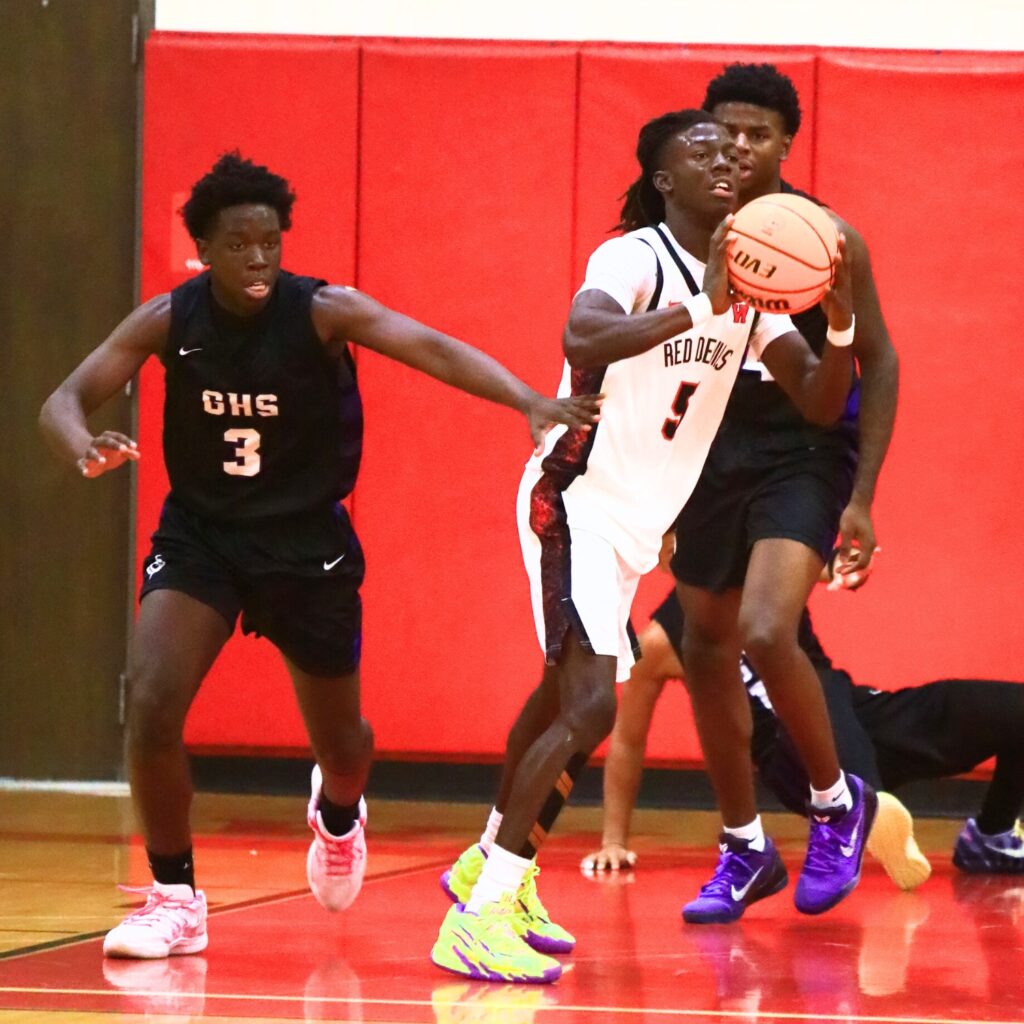 Williston's Treston Jones (5) looks to pass down court after a rebound against Gainesville. Photo by C.J. Gish