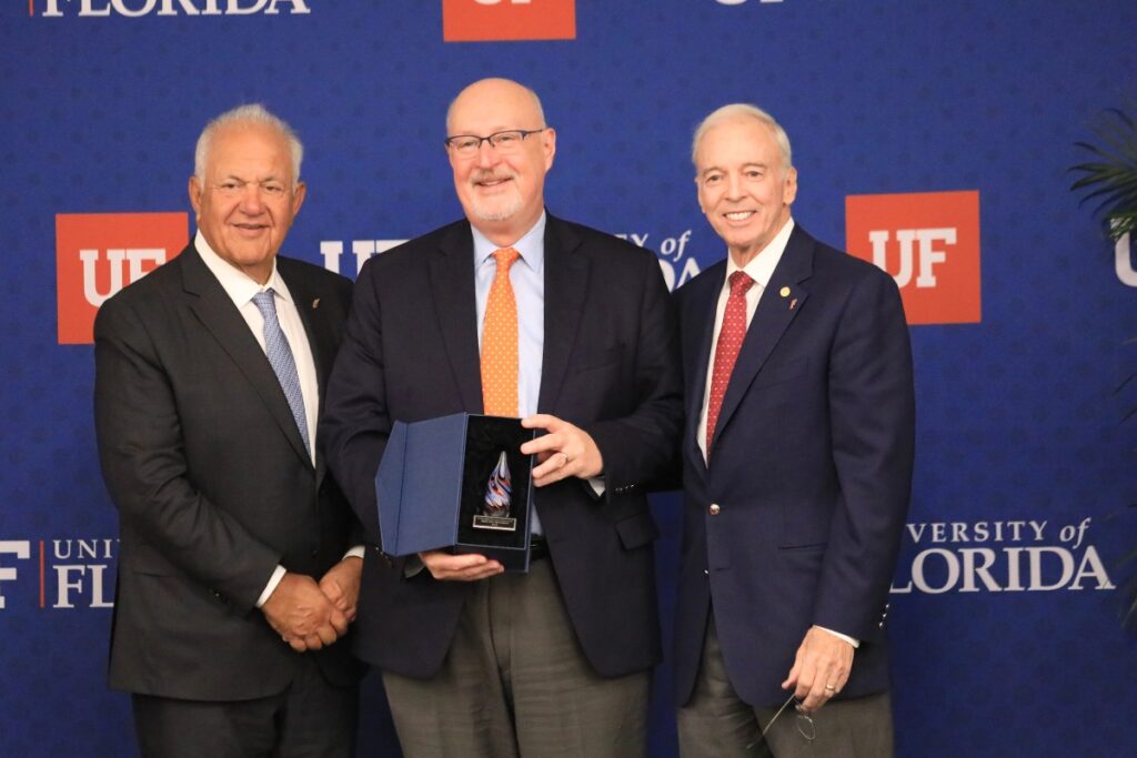 Mayor Harvey Ward (center) accepts the Win Phillips Town Gown Relations Award on behalf of the city of Gainesville along with interim UF President Donald Landry (right) and Board of Trustees Chair Mori Hosseini.