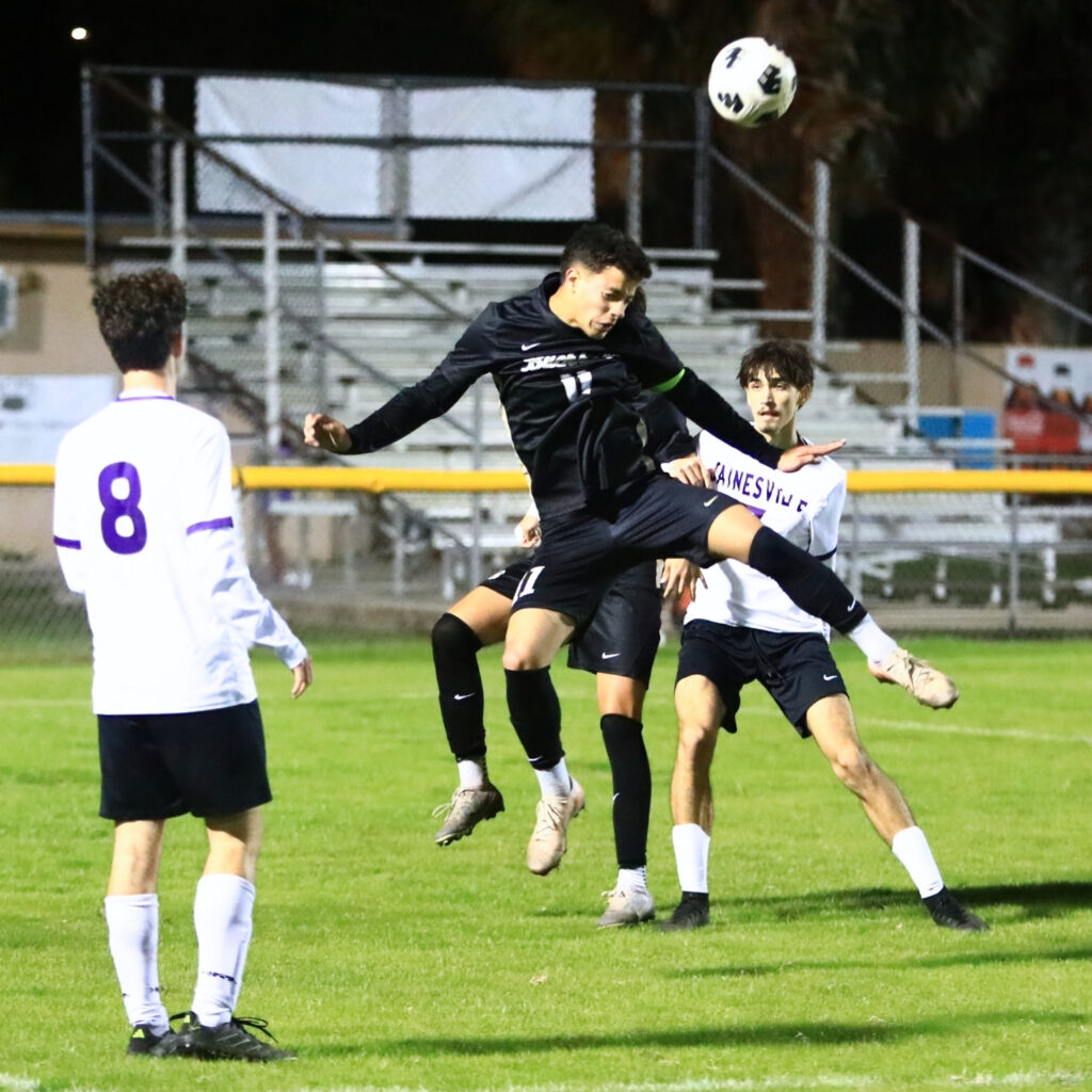 Buchholz's Carlos Cadet (11) with a header against Gainesville. Photo by C.J. Gish
