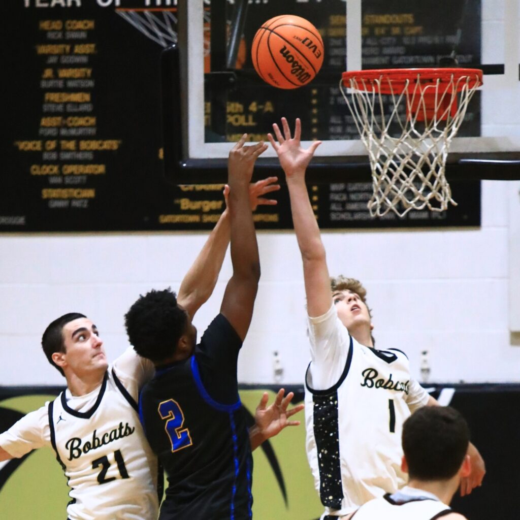 Buchholz's Daniel Muchnick (1) and Gabe Williams (21) attempt to block a shot by Newberry's Kaleb Woods (2). Photo by C.J. Gish