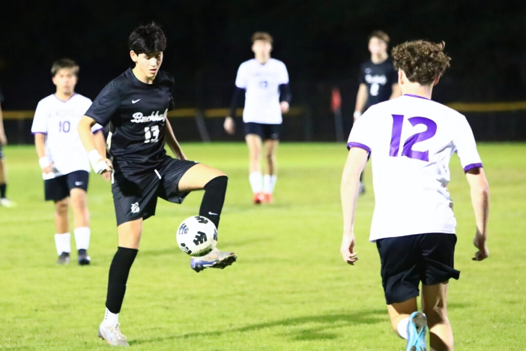Buchholz's Daniel Prieto (13) controls the ball in front of Gainesville's Jacob Eagle (12). Photo by C.J. Gish