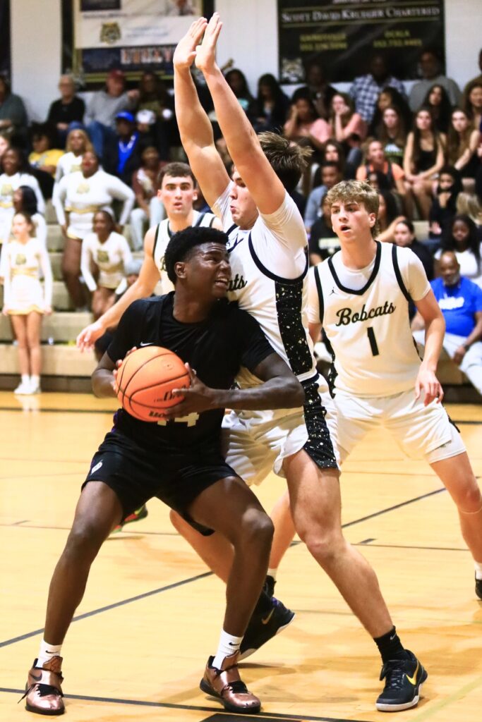 Buchholz's Evan Walker (22) defends against Gainesville's AJ Hall (44). Photo by C.J. Gish