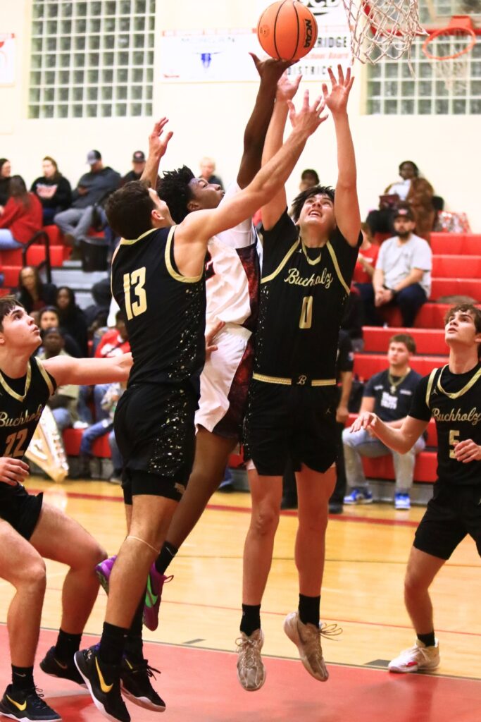 Buchholz's Jacob Bromirski (0) and Jamison McTureous (13) battle Williston's Traeston Armstrong (22) for a rebound. Photo by C.J. Gish
