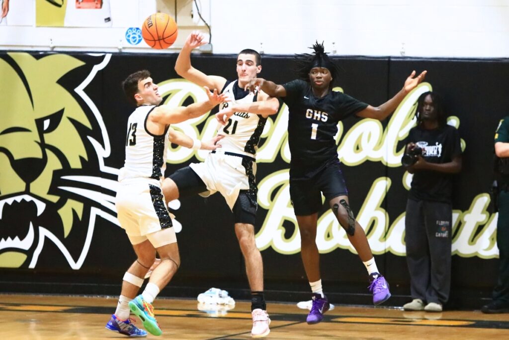 Buchholz's Jamison McTureous (13) and Gabe Williams (21) go after a loose ball against Gainesville's Willie Brooks (1). Photo by C.J. Gish