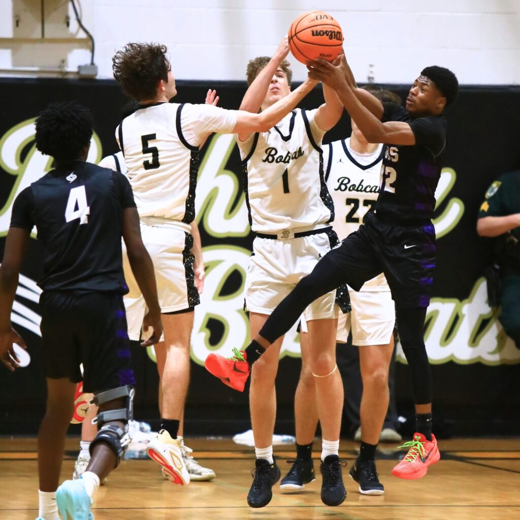 Buchholz's Lucas Bhatia (5) and Daniel Muchnick (1) go after a loose ball against Gainesville's Jaishawn Sanford (12). Photo by C.J. Gish