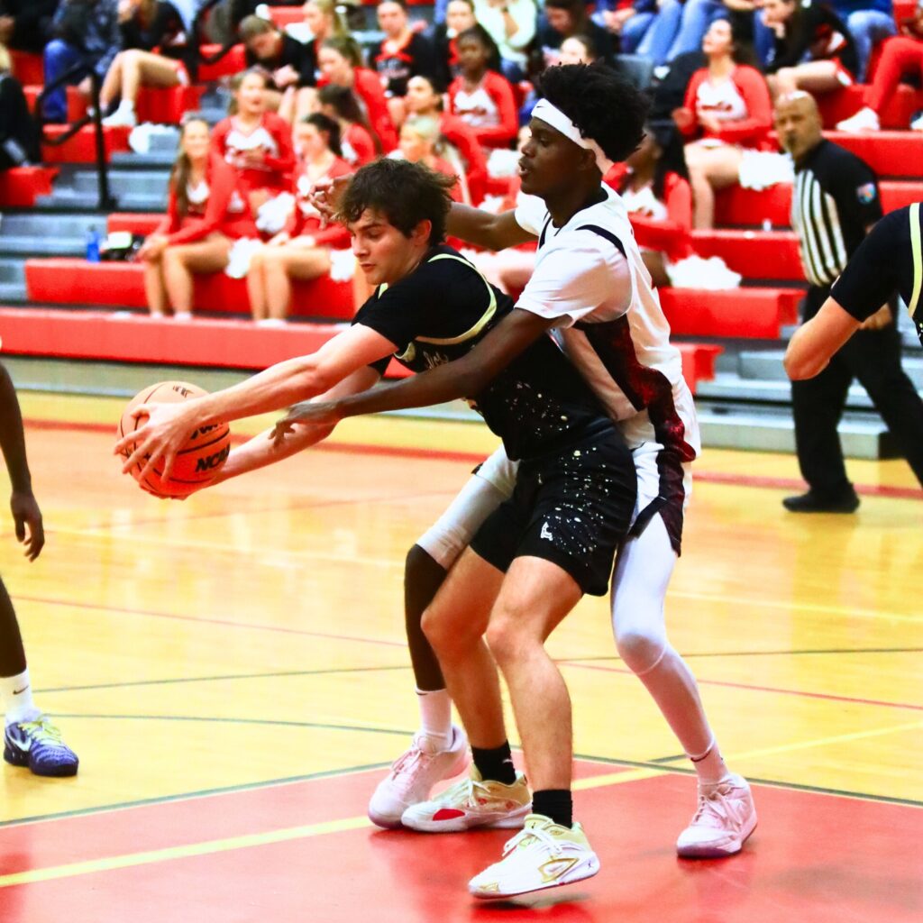 Buchholz's Lucas Bhatia (5) keeps the ball away from Williston's Ke'Marion Ross (4). Photo by C.J. Gish