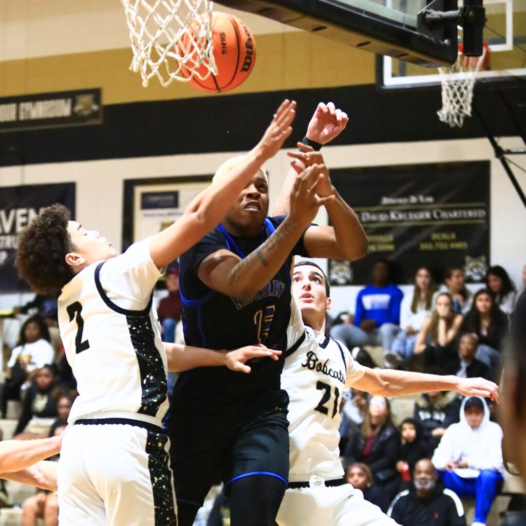Buchholz's Tayshawn Jordan (2) and Gabe Williams (21) defend a shot by Newberry's Brandon Kelly (15). Photo by C.J. Gish