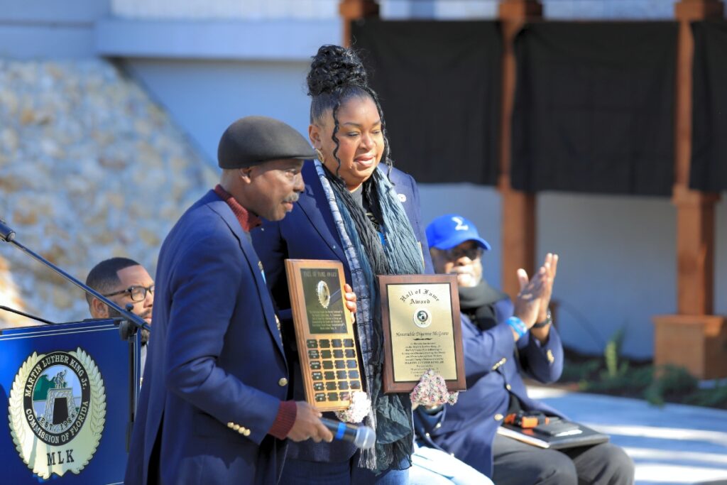 Diyonne McGraw receives the MLK Commission of Florida's Hall of Fame award from Rodney Long.