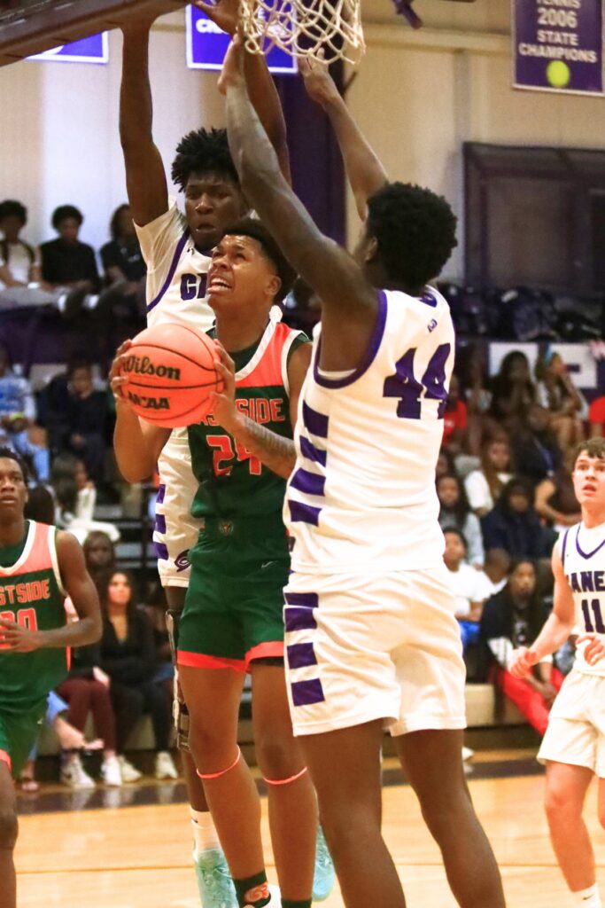 Eastside's Raheem Littles (24) puts up a shot between Gainesville's Craig Thomas Jr. (4) and AJ Hall (44). Photo by C.J. Gish