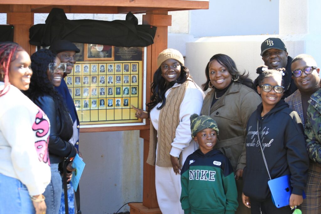 Essence Davis (center) points to her spot on the Hall of Fame at the MLK Memorial Gardens.