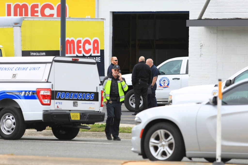 Law enforcement vehicles and personnel gather outside Imeca Hardware & Lumber following the shooting.