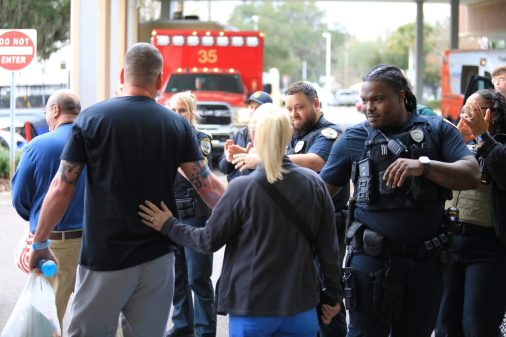 GPD officers clap and celebrate the two injured officers able to leave UF Health Shands Hospital.
