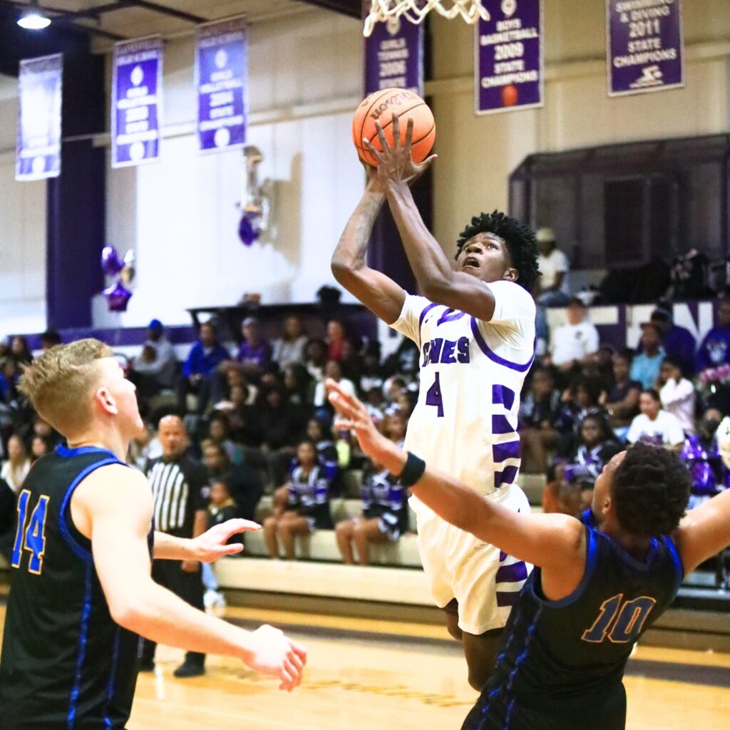 Gainesville's Craig Thomas Jr. (4) drives to the basket against Newberry's Darius Debose (10). Photo by C.J. Gish